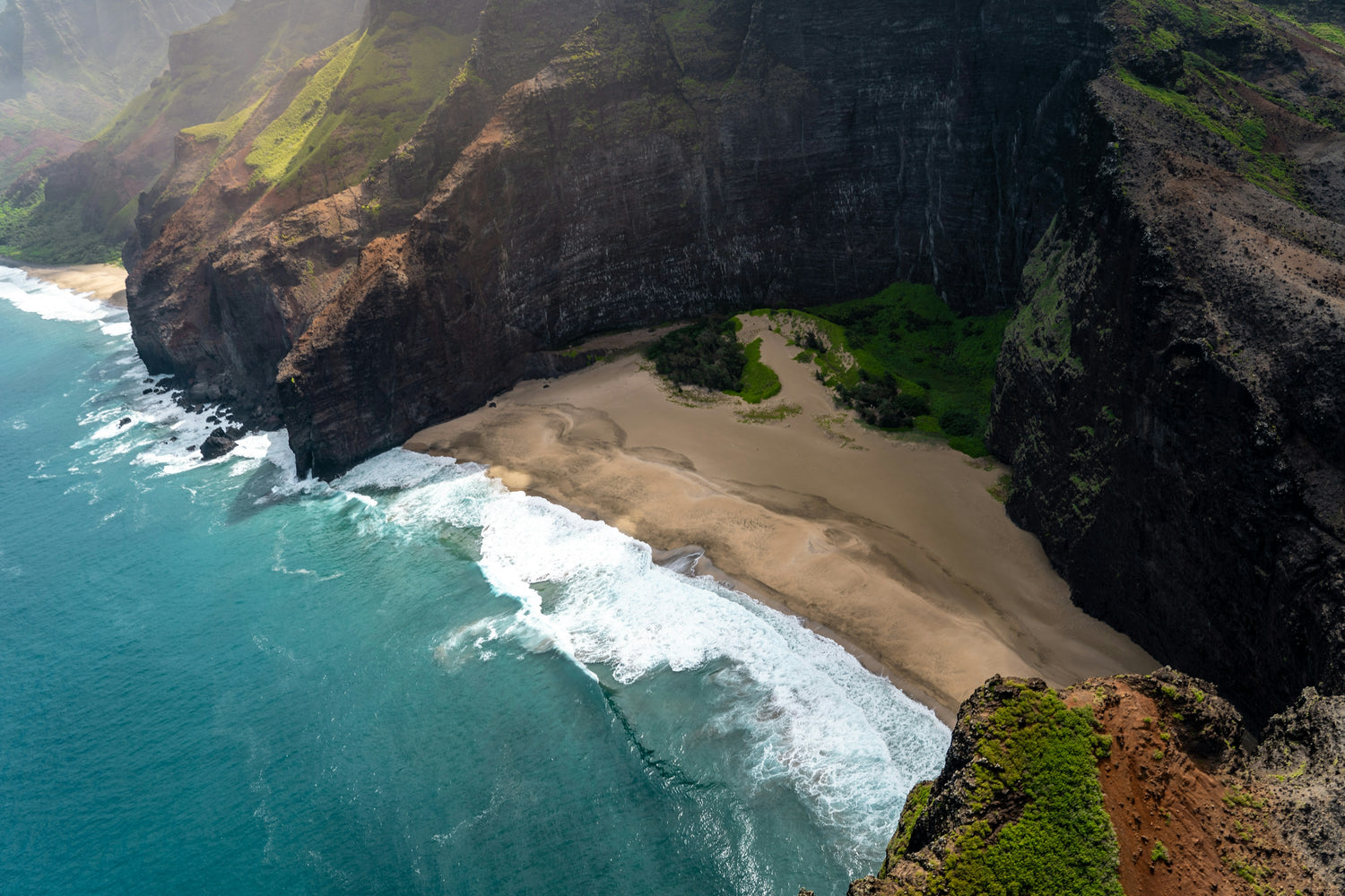 Aerial view of the fluted green cliffs of the Na Pali Coast meeting the ocean on Kauai, Hawaii