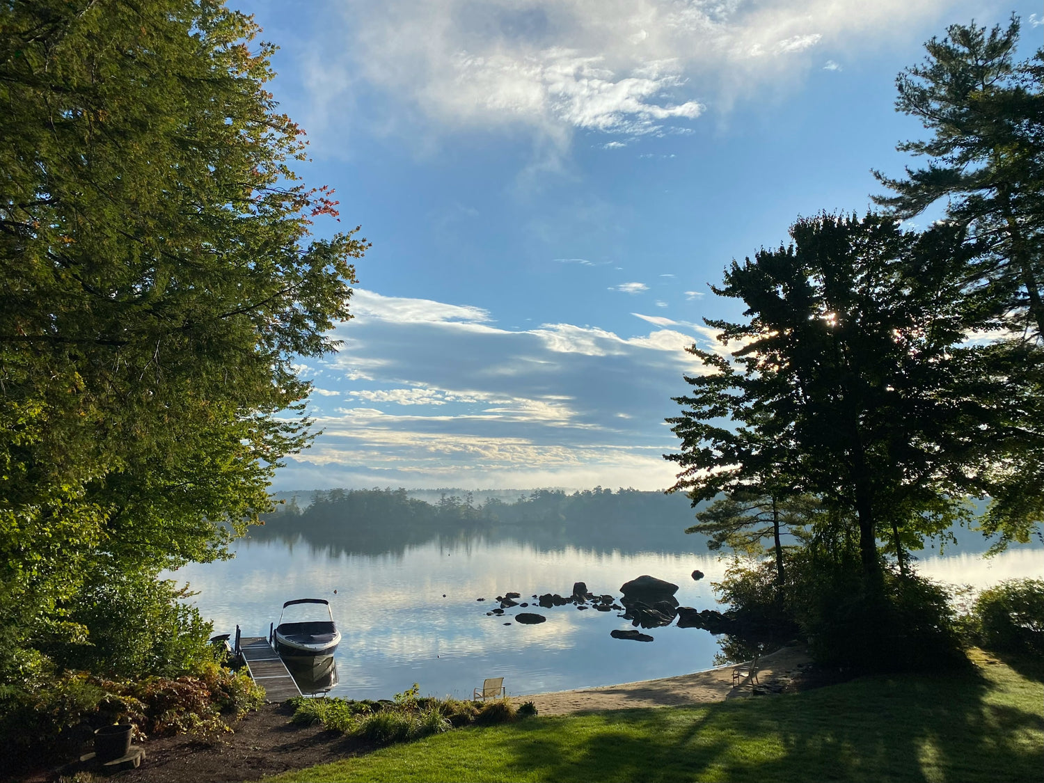 A quiet cove on Lake Winnipesaukee, New Hampshire with a moored boat and pine-lined shore