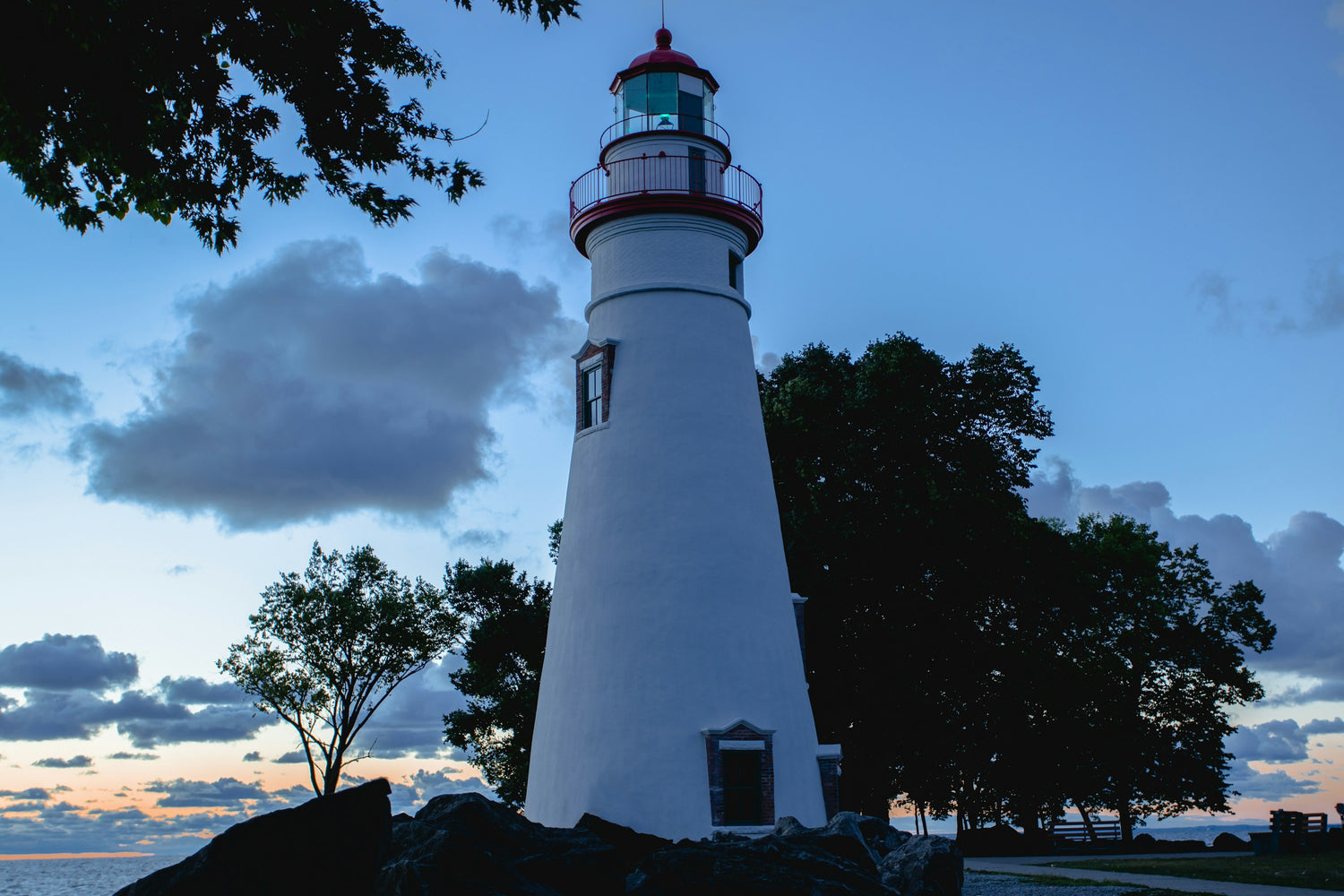 A white and red lighthouse on the limestone shore of Lake Erie in Ohio