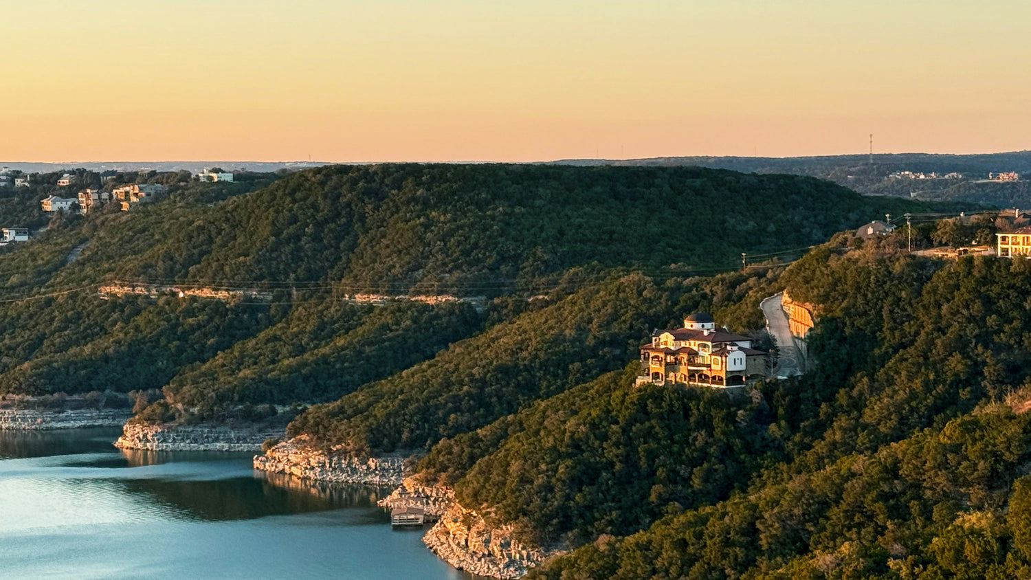 Cedar-covered hills above the calm water of Lake Travis in the Texas Hill Country